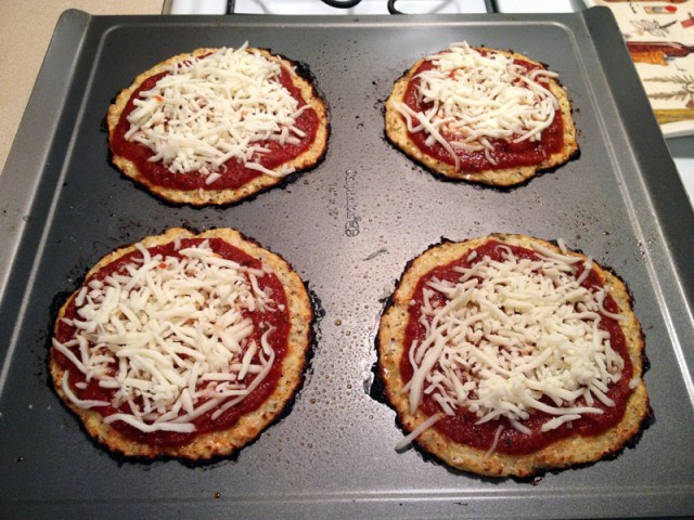 cooked cauliflower crust with tomato sauce and cheese